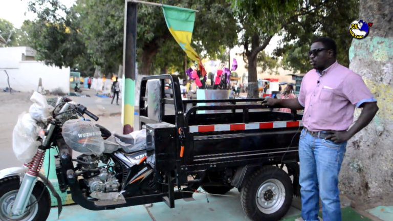 PUB, LAMPE FALL WAKEUR BAYE CHEIKH DIOP PRESENTE LE TRICYCLE VOYAGEUR